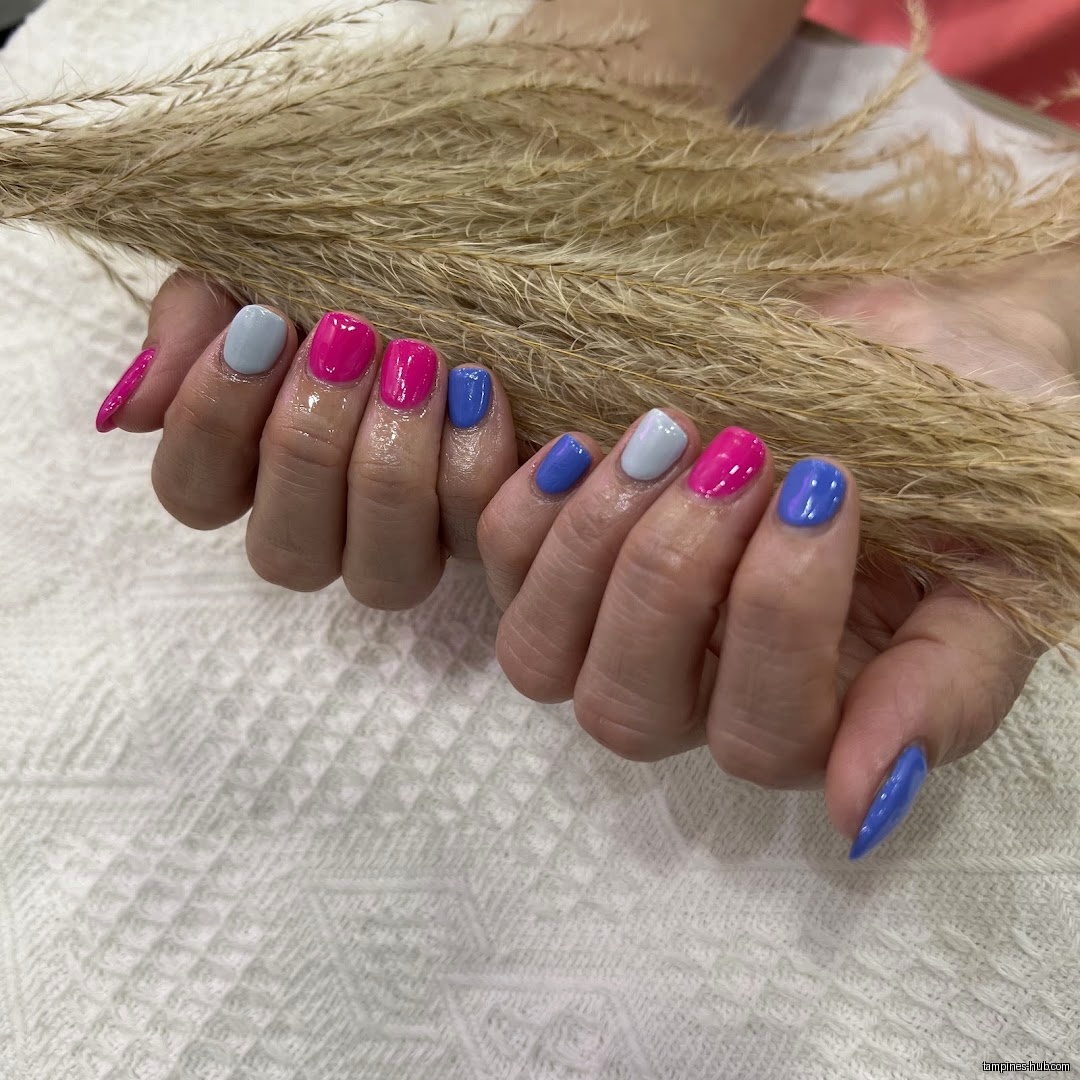 A close-up shows hands with colorful manicured nails holding dried grass.