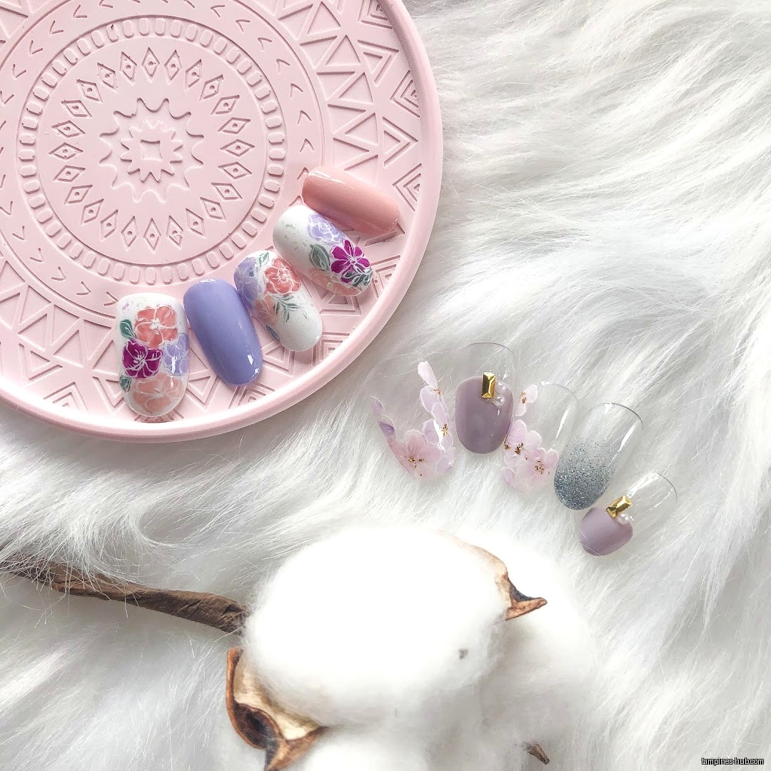 The image shows nail art designs on a pink tray and white fur.