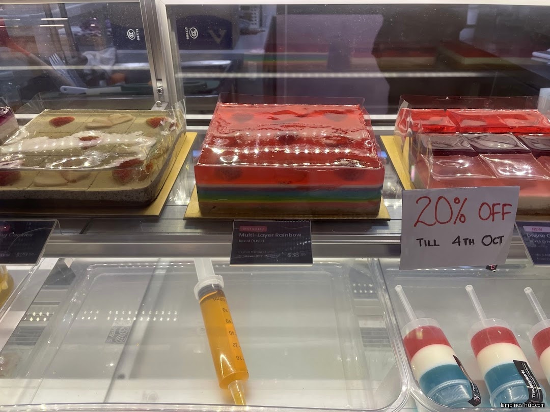 A display case shows various jelly desserts, including rainbow and strawberry flavors.