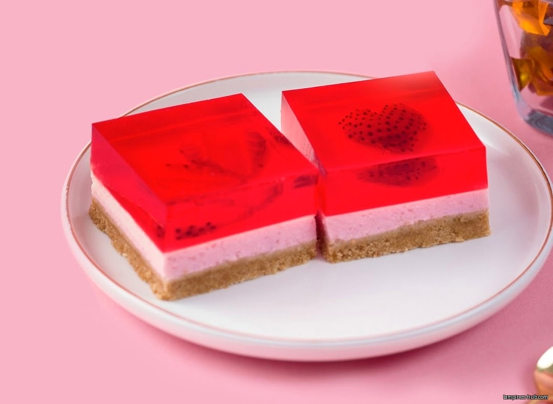 Two strawberry jelly heart desserts on a white plate with pink background.