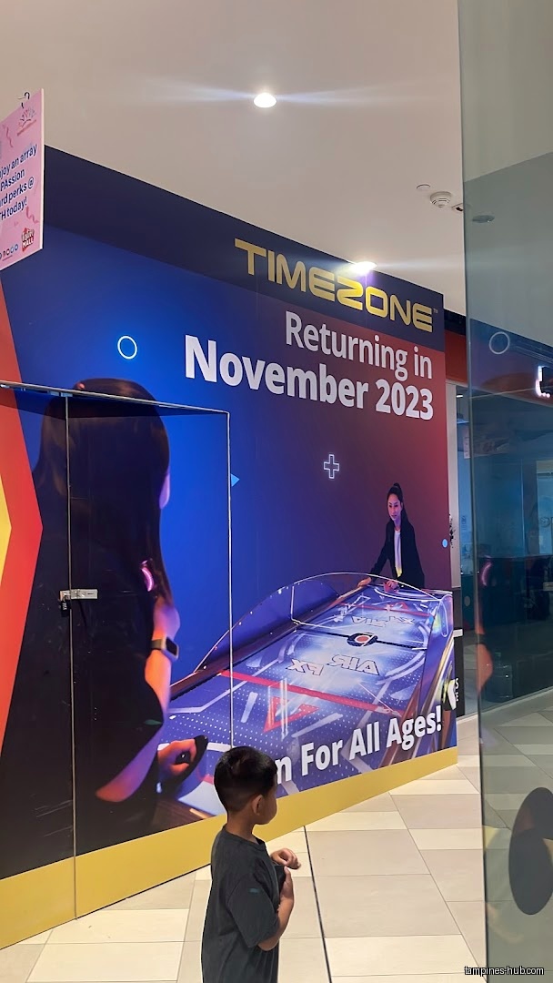 Timezone shop front with a promotional banner and a child in view.