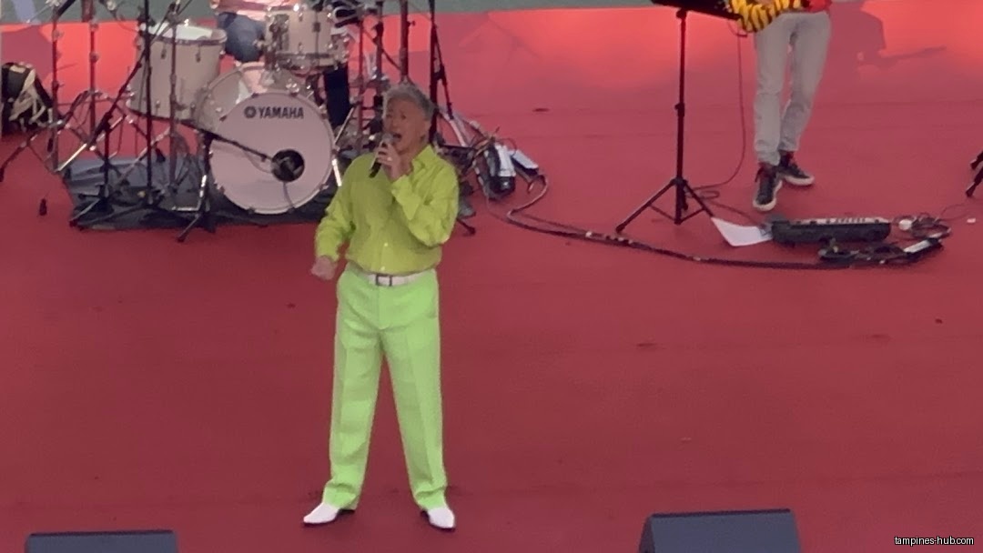 A singer performs on stage with a band at Our Tampines Hub.