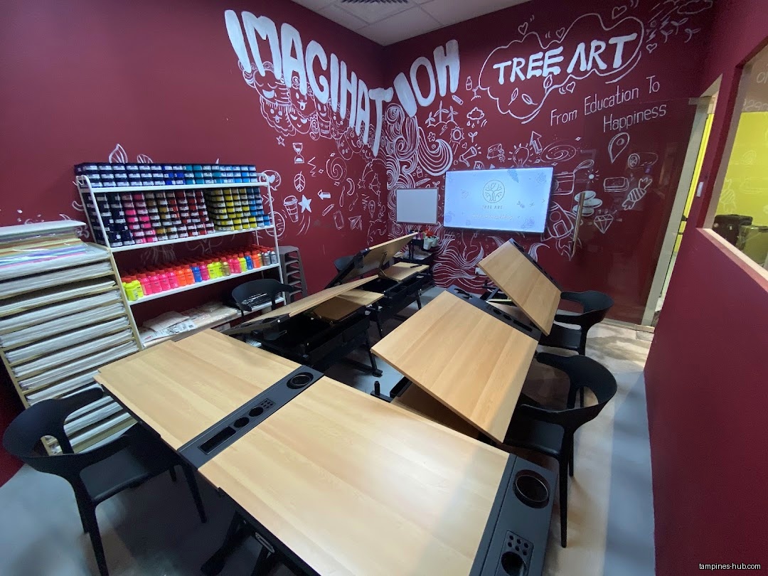 The image shows an art classroom with desks, chairs, and art supplies.