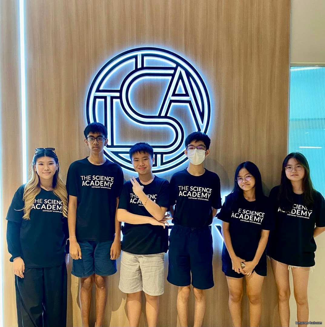 Group of students wearing TSA The Science Academy shirts posing for a photo.