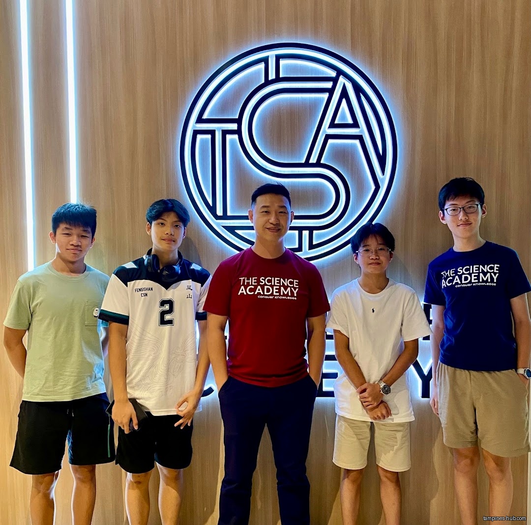 Five people stand in front of TSA THE SCIENCE ACADEMY logo.