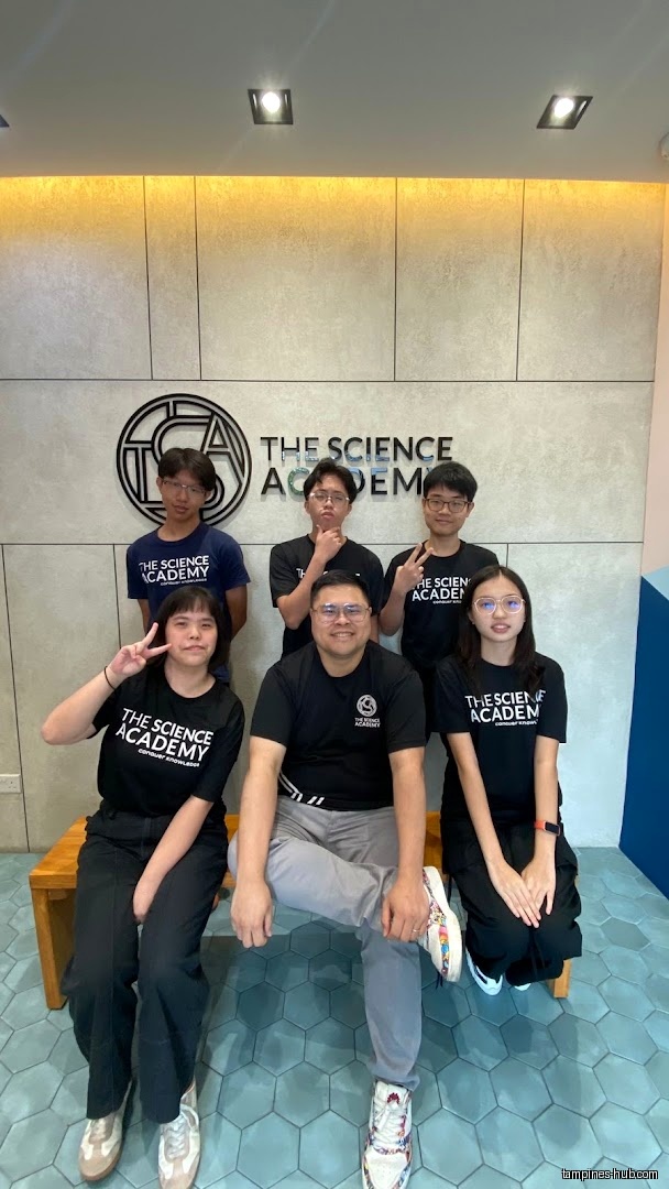 Group photo of staff/students in front of The Science Academy logo.