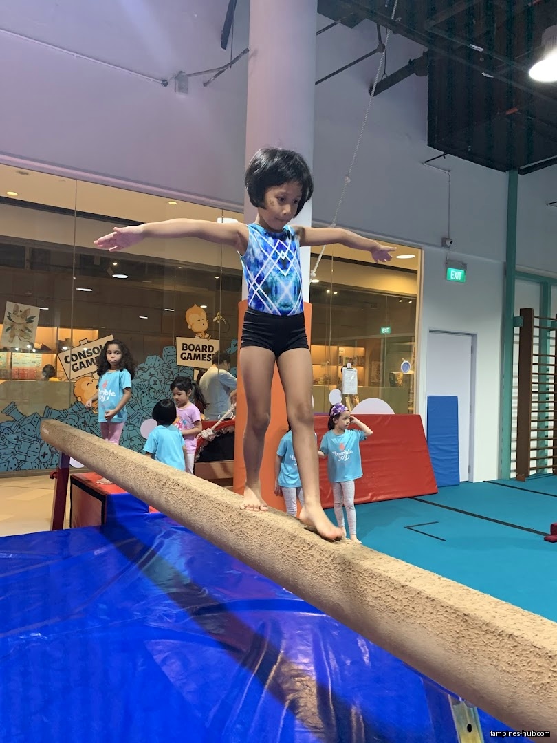 A young girl balances on a beam at Tumble Joy Gymnastics.