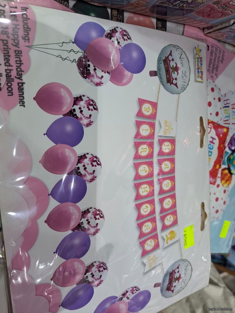 A packaged birthday decoration set with balloons and a banner is shown.