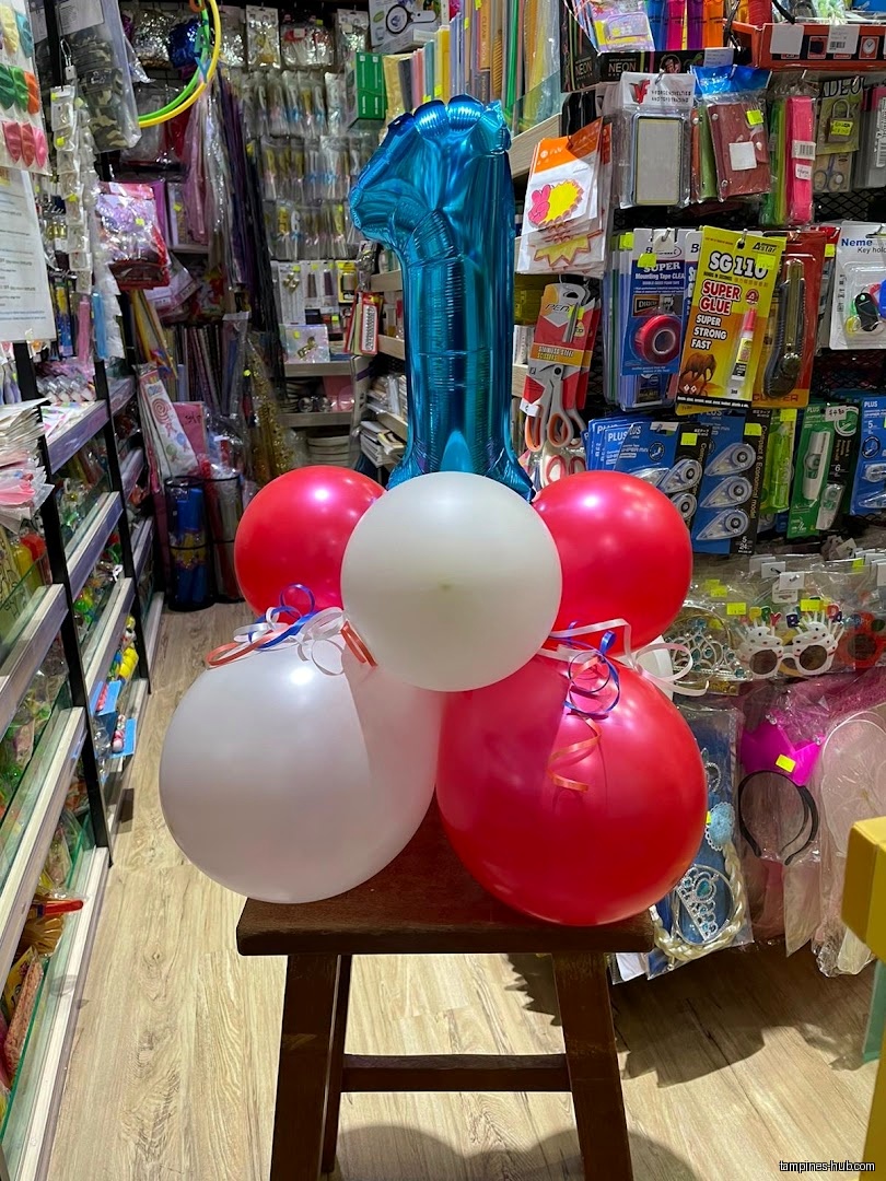 A balloon arrangement with a number one balloon sits on a stool.