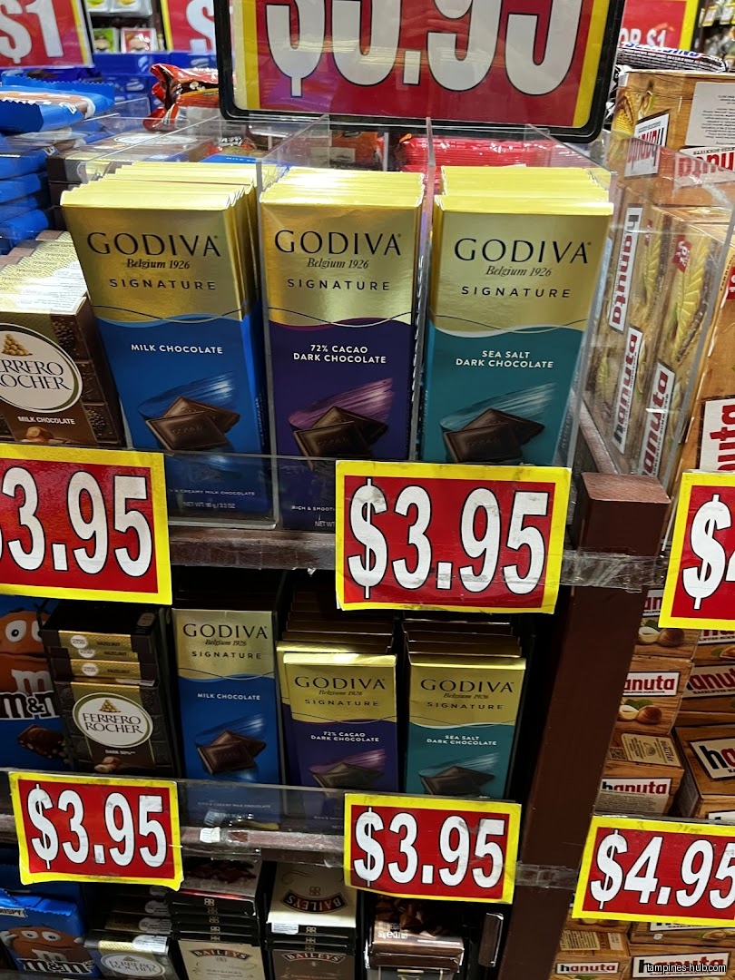 Shelves stocked with Godiva chocolate bars and other candies, with price tags.