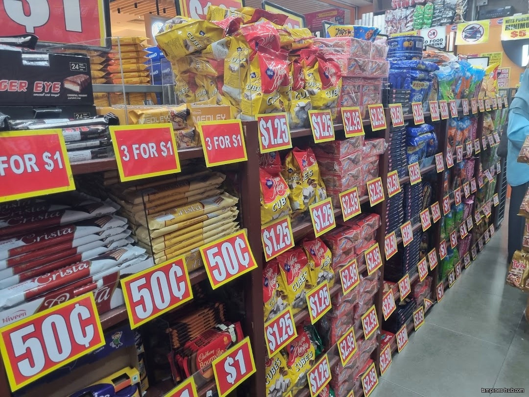 Shelves are stocked with various snacks and chocolates, each marked with prices.