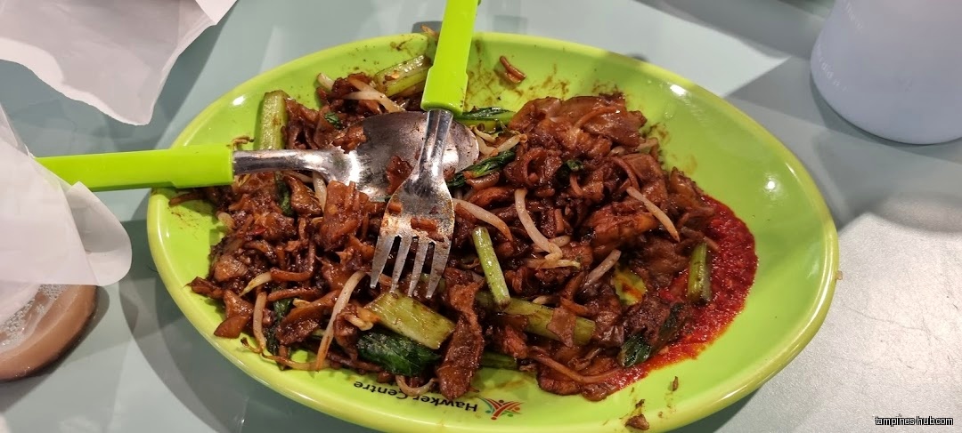 A plate of Char Kway Teow with a fork and spoon.