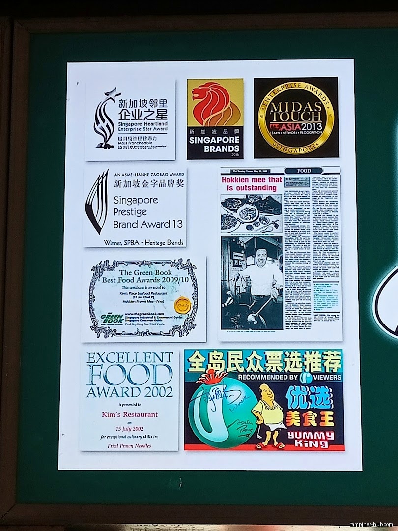 The image shows a collection of awards and newspaper clippings for Kim's Restaurant.
