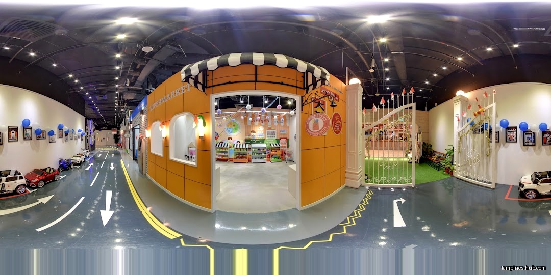 Indoor play area with toy shops, roads, and vehicles for children.