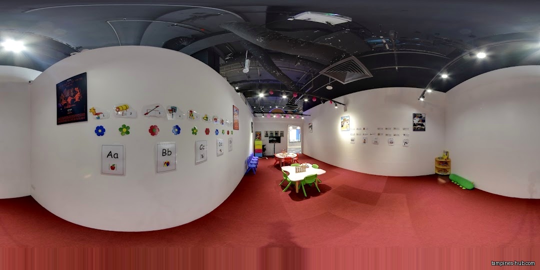The image shows the interior of a children's learning center with tables and decorations.