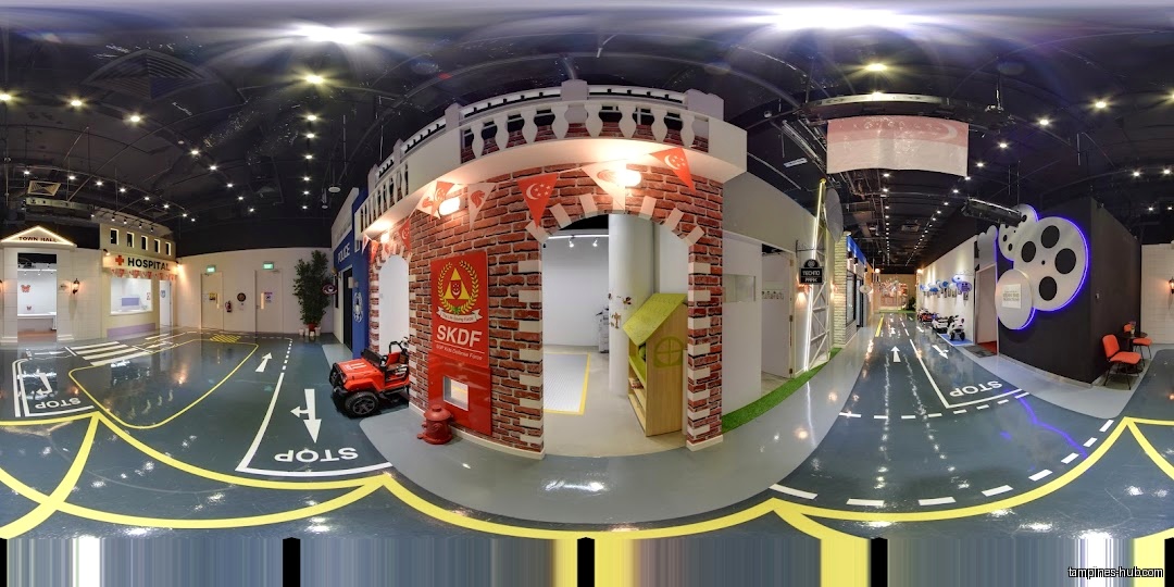 Indoor play area with miniature town buildings and road markings on the floor.