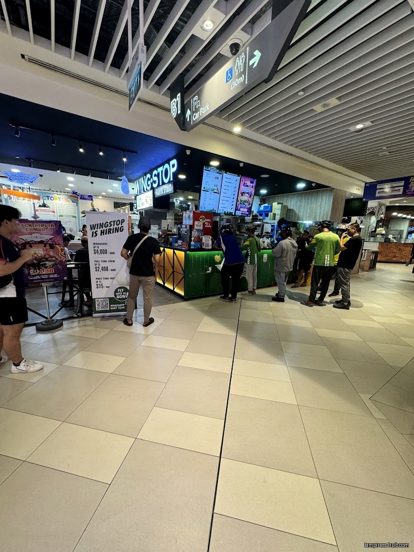Wingstop Our Tampines Hub shop front with customers and hiring sign.