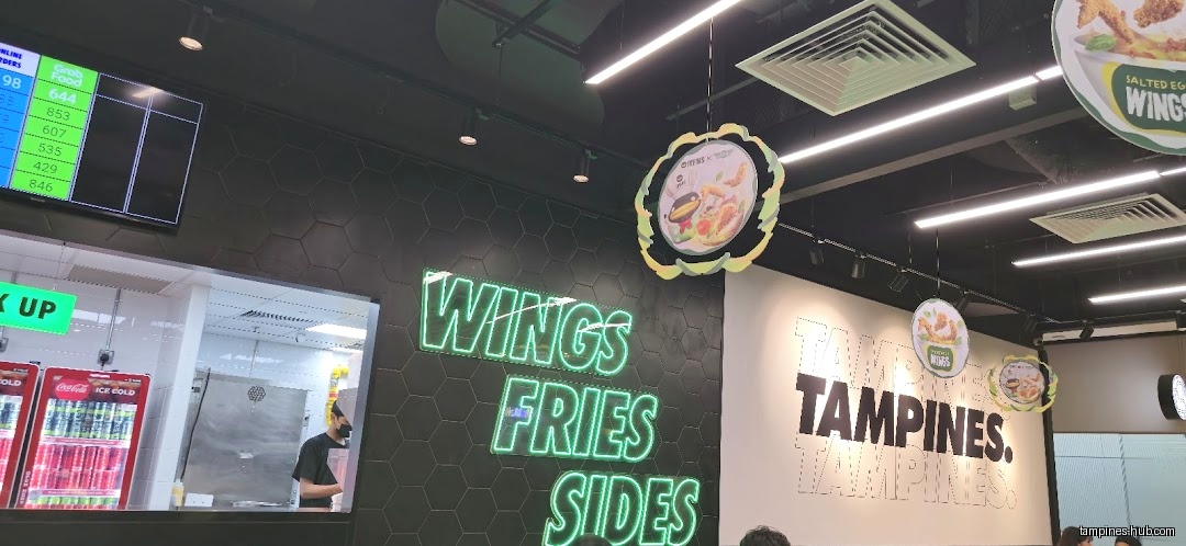 Wingstop interior with neon signs, menu boards, and order pickup area.