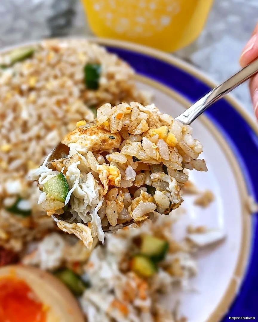 A spoonful of WOK HEY fried rice with egg and cucumber.
