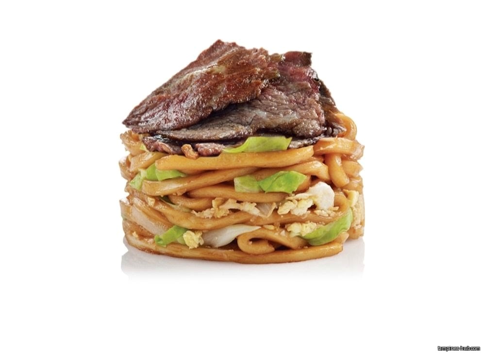 A stack of noodles with beef, egg, and lettuce on a white background.