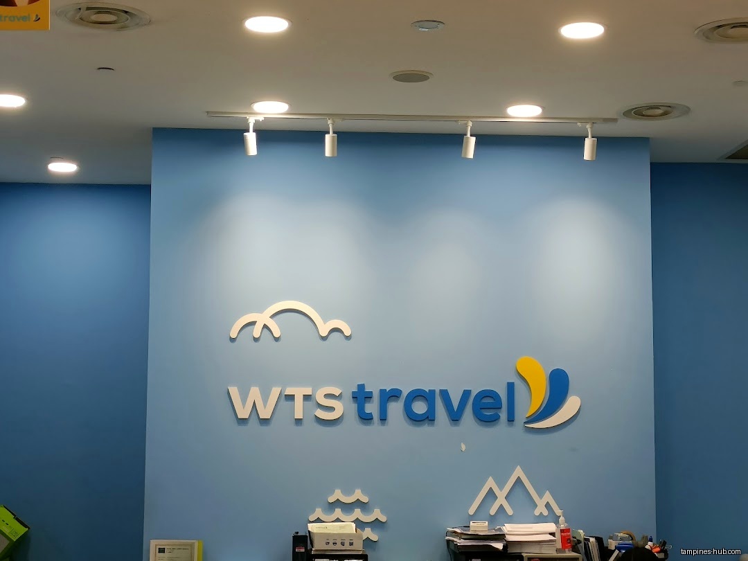 The image shows the WTS Travel & Tours logo on a blue wall.