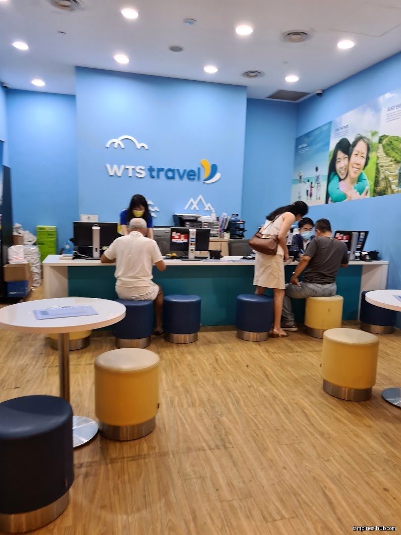 The image shows the interior of WTS Travel & Tours with customers.