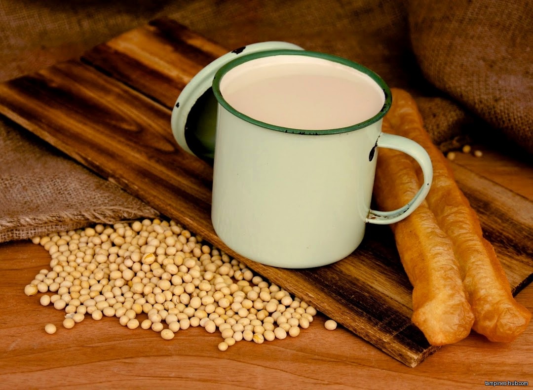 A mug of soy milk with fried dough sticks and soybeans.