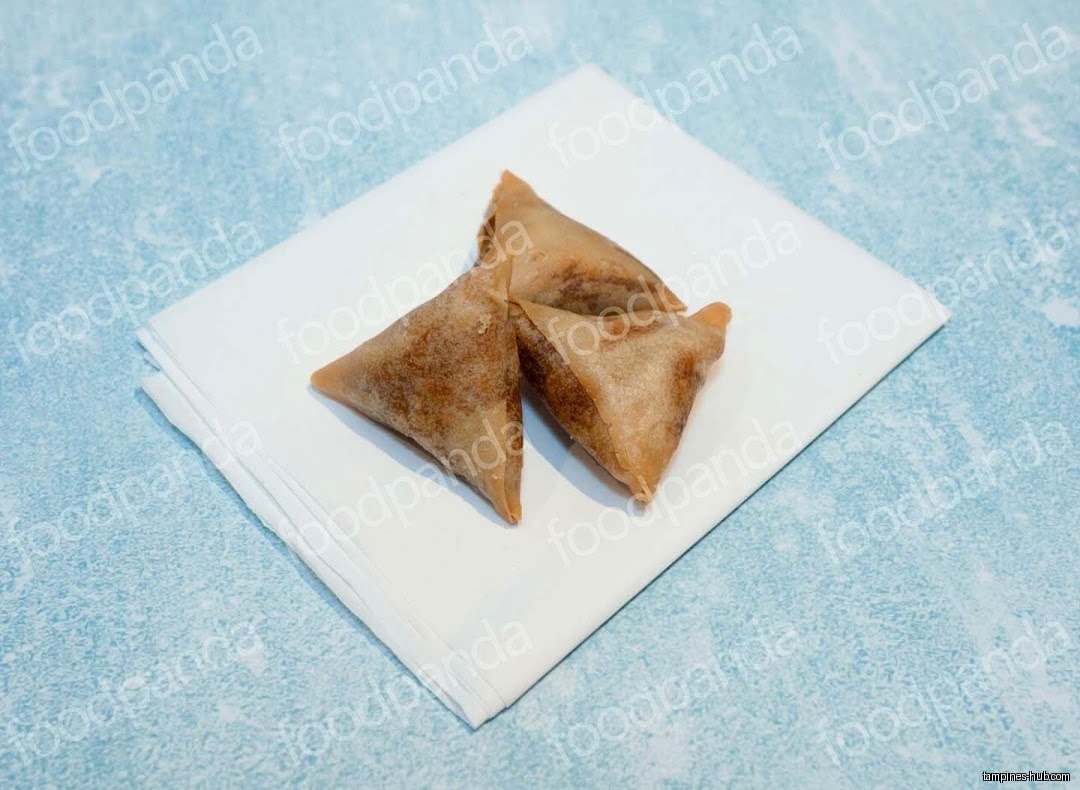Three samosas are placed on a white napkin.