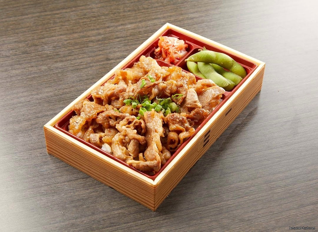 A bento box with meat, rice, edamame, and pickled vegetables.