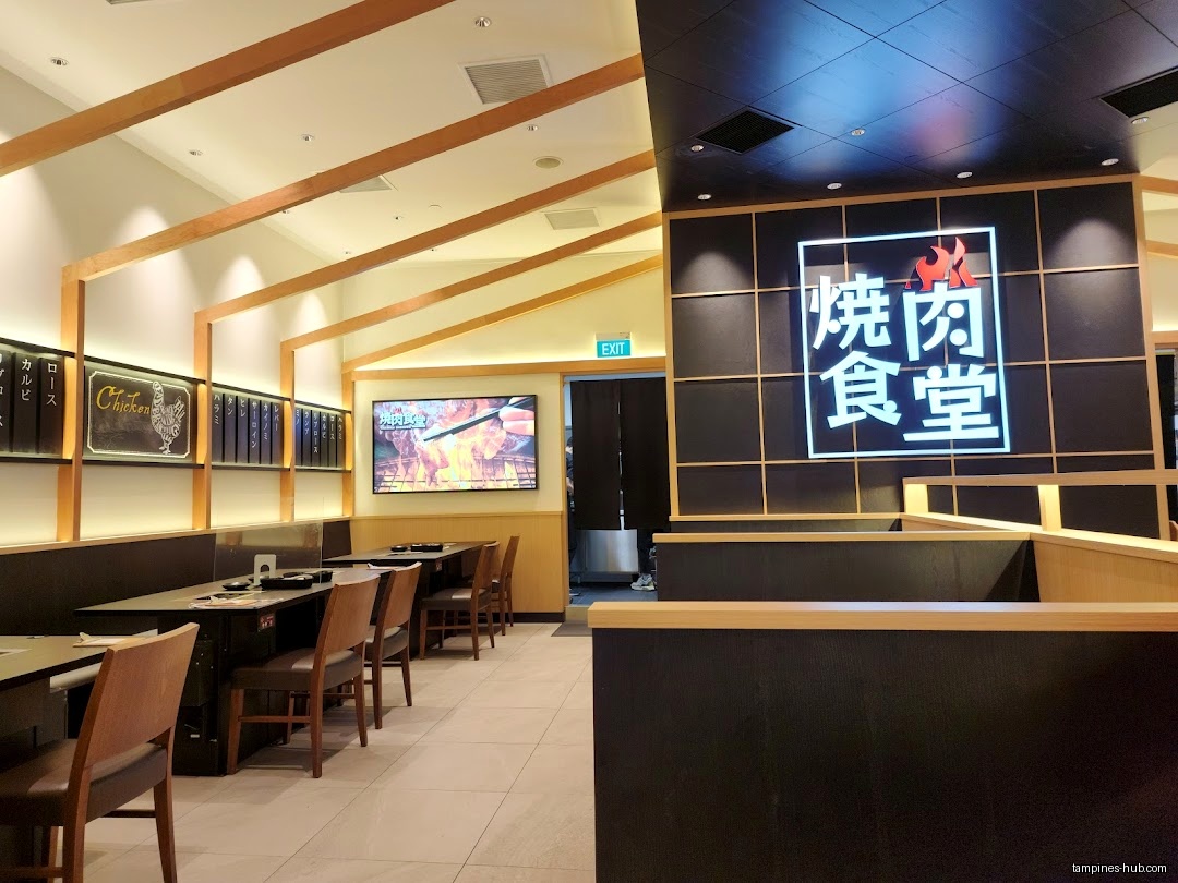 Interior of Yakiniku Shokudo restaurant with tables, chairs, and menu boards.