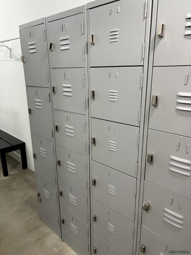 The image shows a row of gray metal lockers and a black bench.