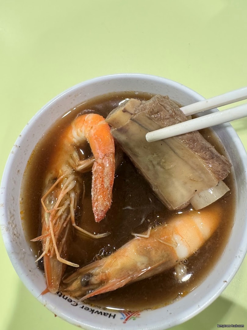 A bowl of prawn noodle soup with prawns and pork ribs.