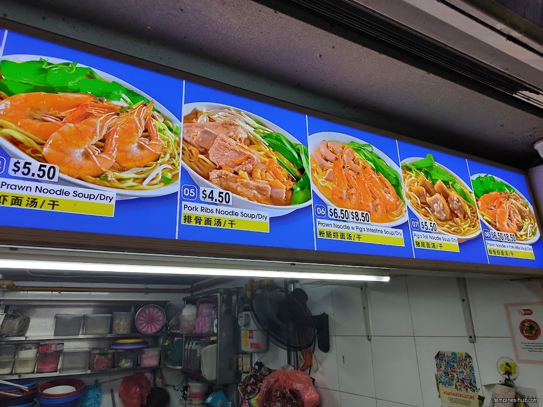 The image shows a menu board with pictures and prices of noodle dishes.