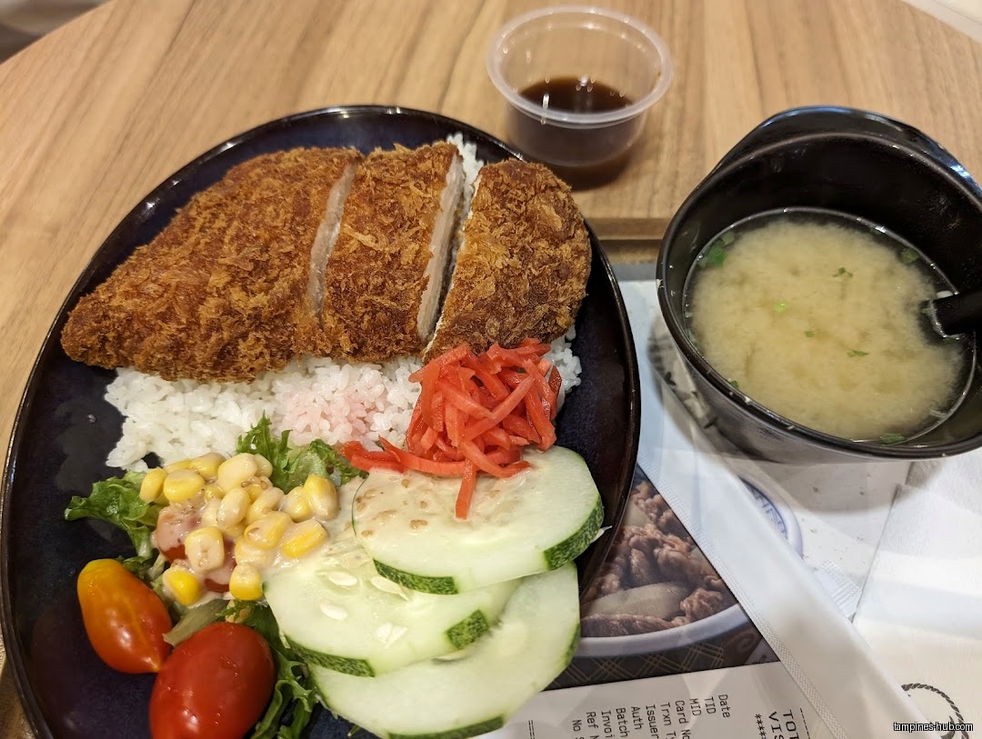 A Yoshinoya meal with tonkatsu, rice, salad, miso soup, and sauce.