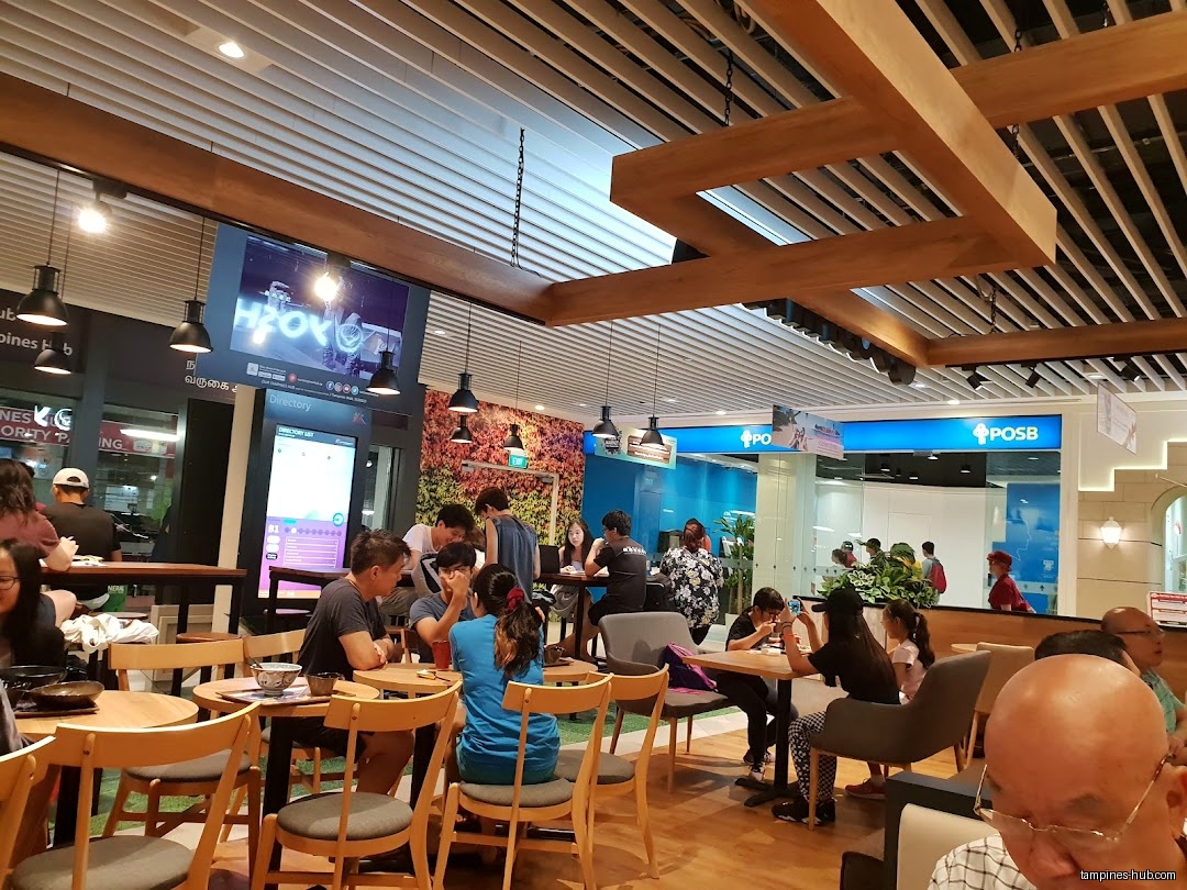 The image shows the interior of Yoshinoya Our Tampines Hub with customers.